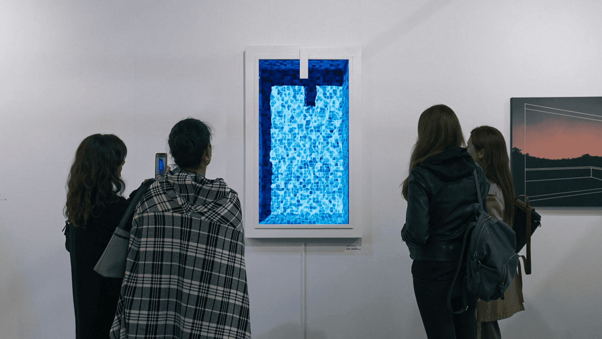 Visitors looking at Ufuk Yılmaz's Pool work at an art fair